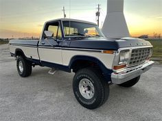 a truck parked in a parking lot with the sun setting on it's horizon