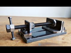 a metal clamp sitting on top of a wooden table