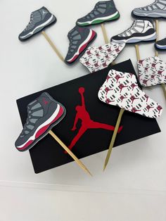 the cupcakes are decorated with air jordan shoes on top of matchestick sticks