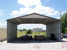 a large metal building sitting on top of a gravel field next to a parking lot