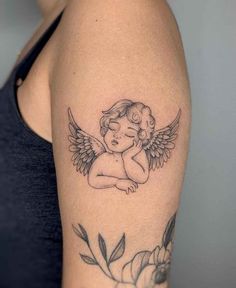 a woman's arm with an angel tattoo on the left side of her arm