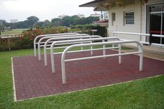 a set of white railings sitting on top of a red brick walkway next to a building