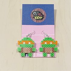 the earrings are made out of legos and have beads on them, with an image of yoshi