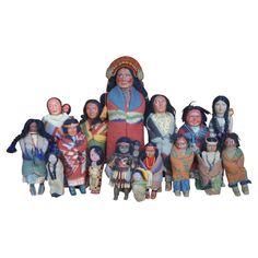 a group of native american dolls sitting next to each other on a white background,