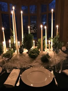 a table set with candles and place settings