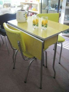 a table with four chairs around it in a room filled with furniture and other items