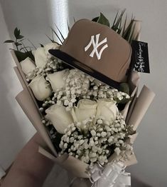 a bouquet of flowers with a baseball cap on top