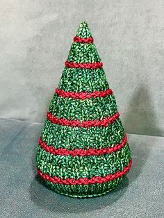 a green knitted christmas tree with red trim on it's top and bottom