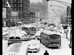 a city street filled with lots of traffic covered in snow