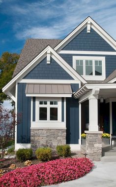 a house with blue siding and white trim on the front door is pictured in this image