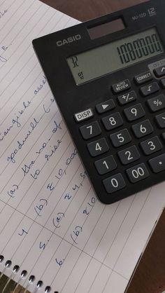 a calculator sitting on top of a piece of paper next to a pen