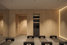 an empty room with yoga mats on the floor and wooden walls, lit by recessed lighting