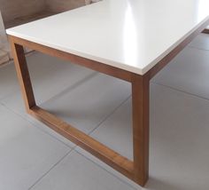 a white table sitting on top of a tile floor next to a wall and window