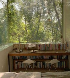 a bedroom with a bed, desk and bookshelf in front of the window