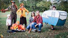 a group of people dressed up in costumes posing for a photo with a trailer behind them