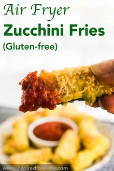 a person holding up a piece of food with sauce on it and the words air fryer zucchini fries gluten - free