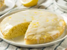 a lemon cake on a plate with a slice cut out