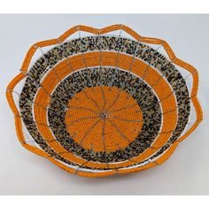 an orange and black basket with beads on it