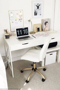 a white desk with a laptop computer on top of it and pictures above the desk