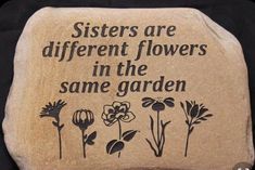 there is a stone with flowers on it that says sisters are different flowers in the same garden