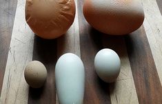 an assortment of eggs sitting on top of a wooden table