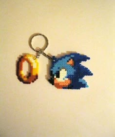 a pixelated sonic the hedgehog keychain hanging on a wall