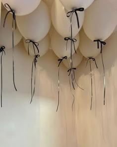 white balloons tied to the ceiling with black ribbons