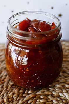 a glass jar filled with jam sitting on top of a table