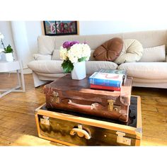 two suitcases are stacked on top of each other in front of a coffee table