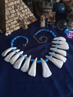 Here is a Lovely Blue Buffalo Tooth Necklace. It is made with 13 Buffalo Teeth. This Necklace is Beaded with Blue Glass Beads. It is Adjustable 20 - 25 inches and Strung With 40 Lb test line. All Items Ship Within 1-3 Days via USPS Ground Advantage Service. Shipping on these will be 5.50 (USA Only) All additional items are FREE! International Shipping Will Be 22.00 + 2.00 For each Additional Item. Canada 20.00 + 2.00 For each Additional Item. International Shipping May Take 2 - 6 Weeks to Delive Costume Viking, Aip Diet, Human Bones, Witch Doctor, Teeth Jewelry, Blue Buffalo, Bone Necklace, Tooth Necklace, Bone Jewelry