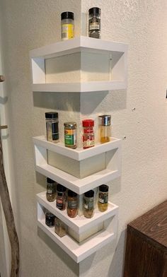 three white shelves with spices on them