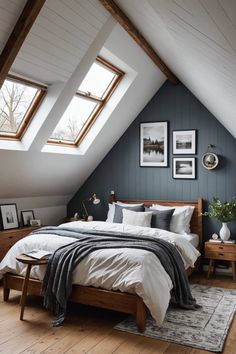 a bed sitting under two windows in a bedroom next to a wooden table and chair