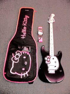 an electric guitar and hello kitty case on the ground