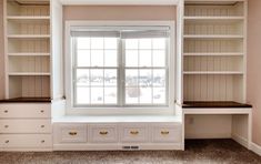 an empty room with built in bookshelves and drawers