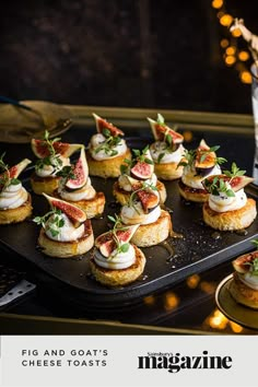 small appetizers are arranged on a black tray with lights in the back ground