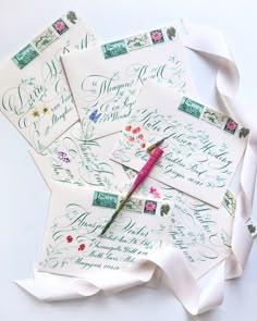 the envelopes have been decorated with flowers and calligraphy, along with a pink pen