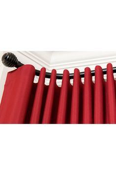 a red curtain is hanging on the side of a white wall with a black handle