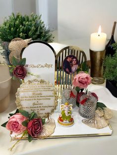 a table topped with flowers and pictures next to candles