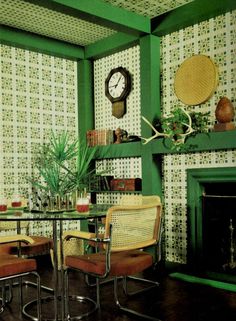 a dining room with green walls and chairs