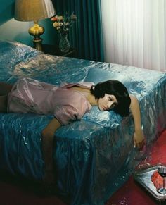 a woman laying on top of a bed covered in plastic covering it's sides