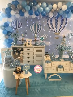 a baby's room decorated in blue and white with balloons on the wall, teddy bears