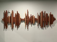 a sculpture made out of wood sticks on the wall next to a phone charger