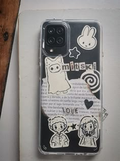 an iphone case with stickers on it sitting next to a piece of paper that says, i love you