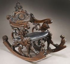 an antique rocking chair with lions on it's back and foot rests in front of the seat