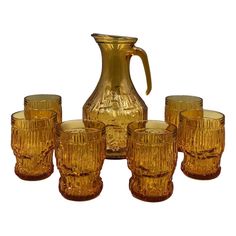 a pitcher and six glasses are sitting next to each other