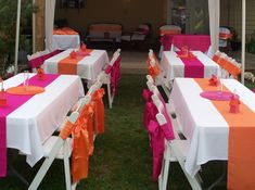 tables with orange and pink tablecloths are set up for an outdoor function in the backyard