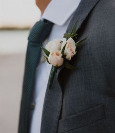 a man wearing a suit and tie with flowers on it's lapel flower