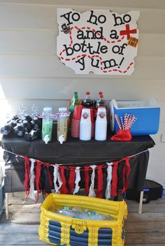 a table topped with lots of bottles and drinks next to a sign that says yo hoo and a bottle of yum