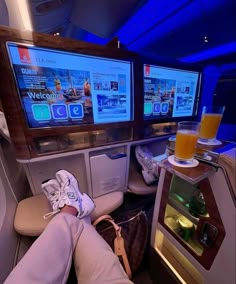 the inside of an airplane with two televisions on each side and drinks in front of them