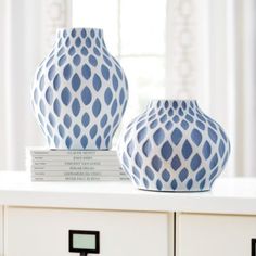 two blue and white vases sitting on top of a table next to each other